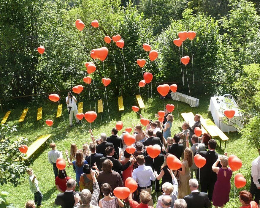 Luftballons lassen die guten Wünsche der Hochzeitsgäste für das Brautpaar in den Himmel fliegen