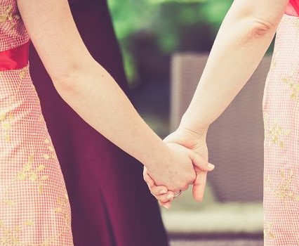 Zwei Frauen, die sich an den Händen halten
